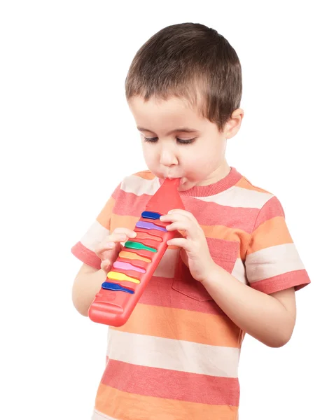 Kleine jongen speelt speelgoed mondharmonica — Stockfoto