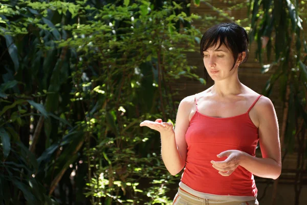 Жінка в джунглях тримає тропічні фрукти на руці — стокове фото