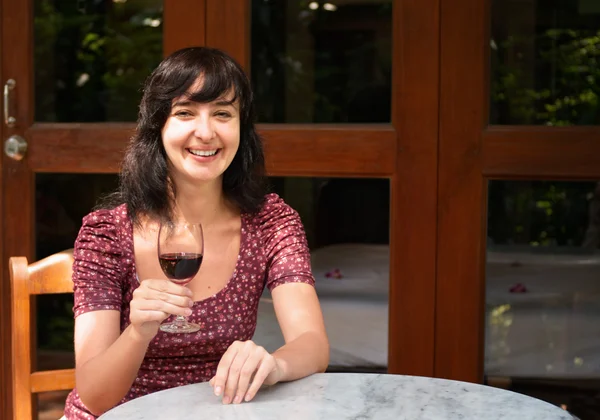 Женщина пьет вино на веранде — стоковое фото