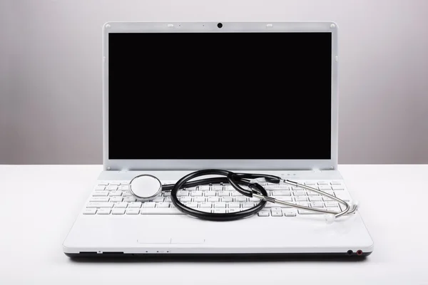 Stetoskop a bílý laptop — Stock fotografie