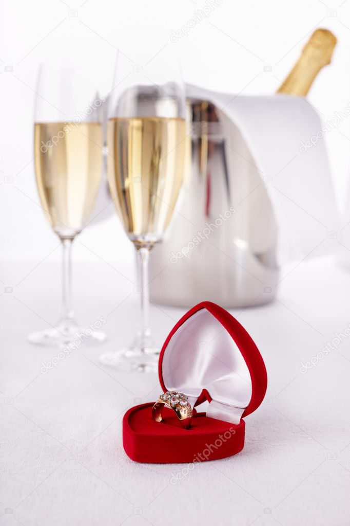 Wine Glasses with champagne and Engagement Ring, selective focus on nearest