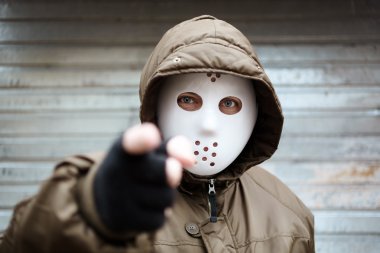 Anonymous man with plastic mask , criminal concept, selective focus on eye clipart
