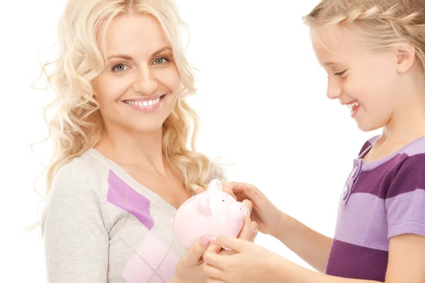 Mother and little girl with piggy bank — Stock Photo, Image