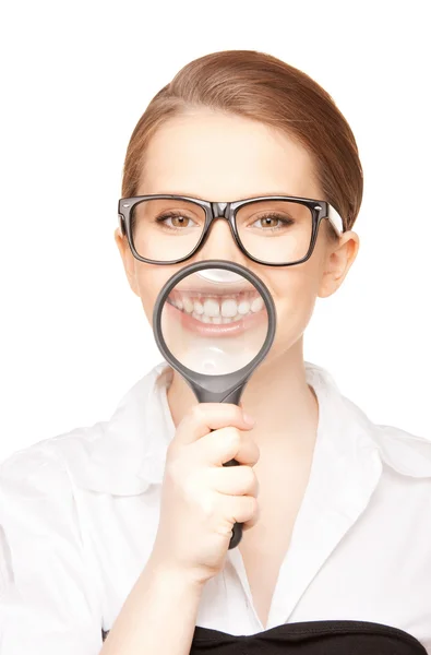 Жінка зі збільшувальним склом, що показує зуби — стокове фото