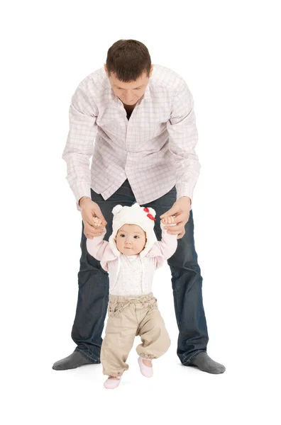 Дитина робить перші кроки з допомогою батька — стокове фото