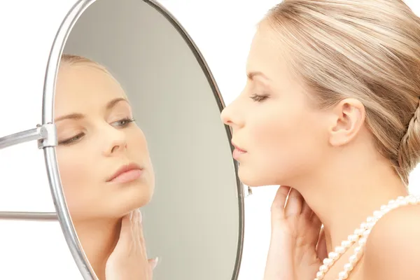 Красива жінка з перловим бісером і дзеркалом — стокове фото