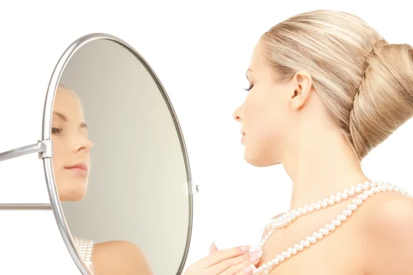 stock image Beautiful woman with pearl beads and mirror