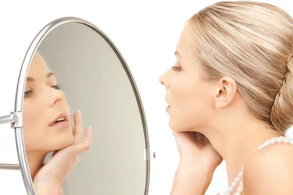 Красивая женщина с жемчужными бусами и зеркалом — стоковое фото