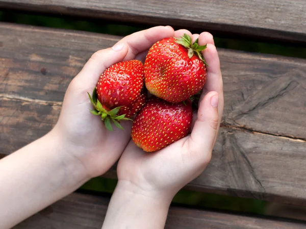 成熟的草莓在婴儿手臂 — 图库照片