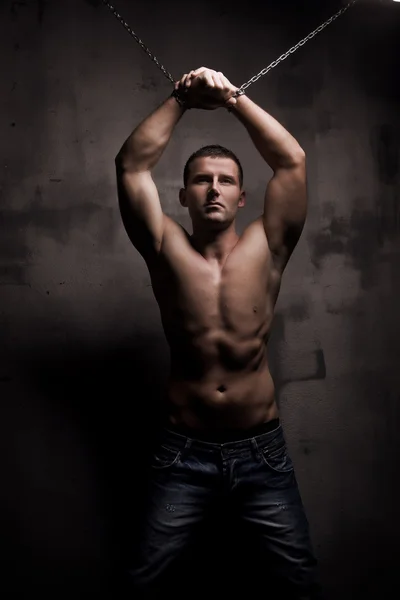 Giovane modello maschile ben costruire con catene sopra le braccia — Foto Stock