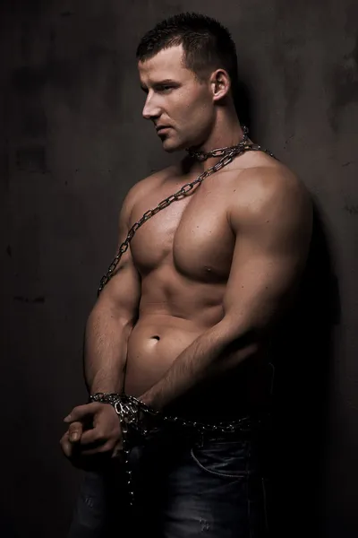 Mladý mužský model dobře stavět s řetězy nad jeho tělem — Stock fotografie