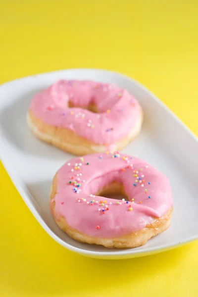 Donut de morango dentro do prato no fundo de cor amarela — Fotografia de Stock