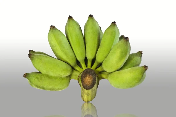Banana verde su fondo pavimento riflettente — Foto Stock
