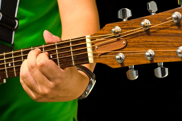 Чоловік грає на гітарі на чорному тлі — стокове фото