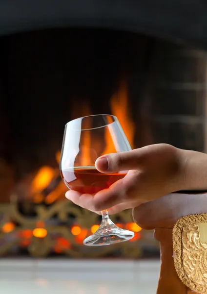 Stock image Resting at the burning fireplace fire with a glass of cognac