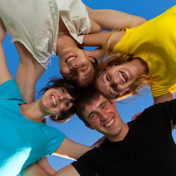 Below view of joyful teens embracing and looking at camera with — Stock Photo, Image