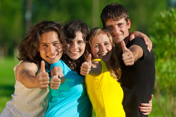 Young group of happy friends showing thumbs up sign — Stock Photo, Image