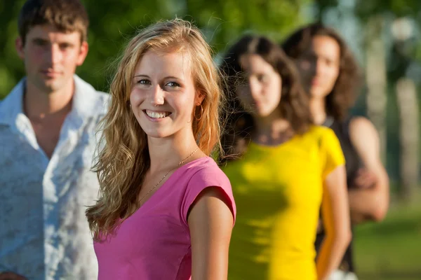 The girl and her friends in the park — Stock Photo, Image