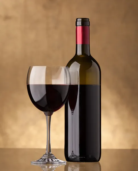 Uma garrafa de vinho tinto e encheu um copo de vinho — Fotografia de Stock