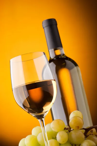 Нижний вид на стакан бутылки белого вина и винограда — стоковое фото