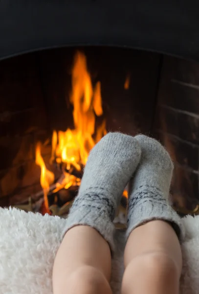 Los pies de los niños se calientan en la chimenea —  Fotos de Stock