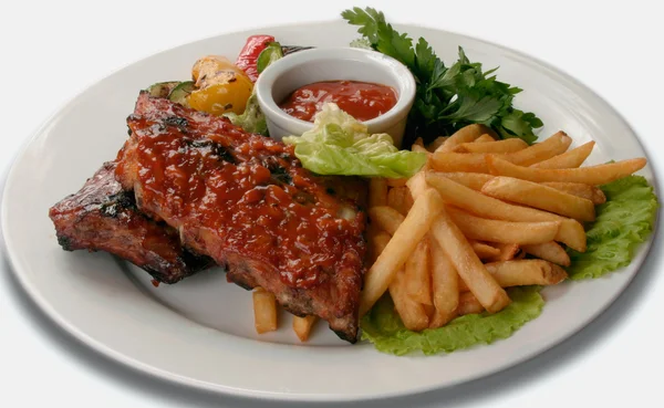 Pork ribs under a red sauce with fries — Stock Photo, Image