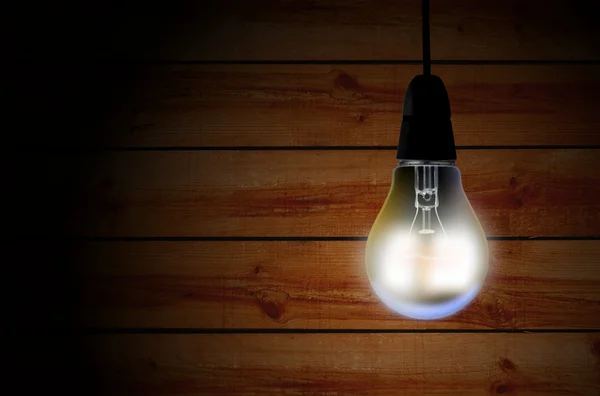 Light bulb over wooden background — Stock Photo, Image
