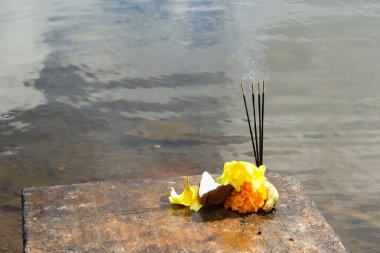 Sandal sticks, fruits and flowers as offerings during a prayer at the water's side, a Hindu ritual. clipart