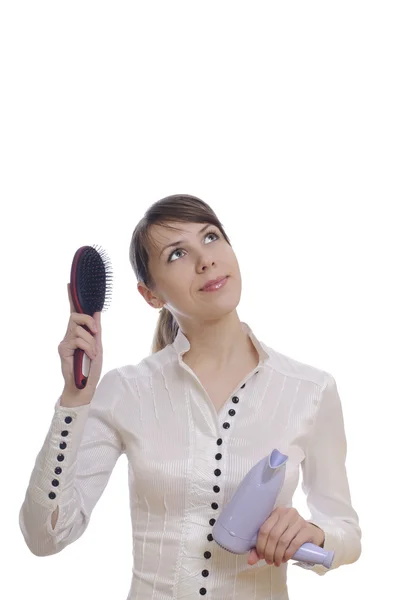 Thinking woman with hairbrush and dryer — Stock Photo, Image