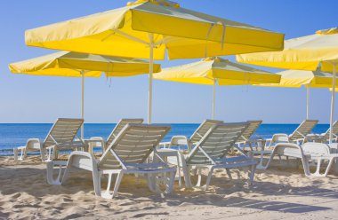 Chairs and umbrellas on the beach clipart