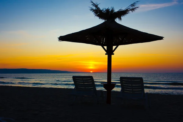 Liegestühle und Sonnenschirme am Strand — Stockfoto