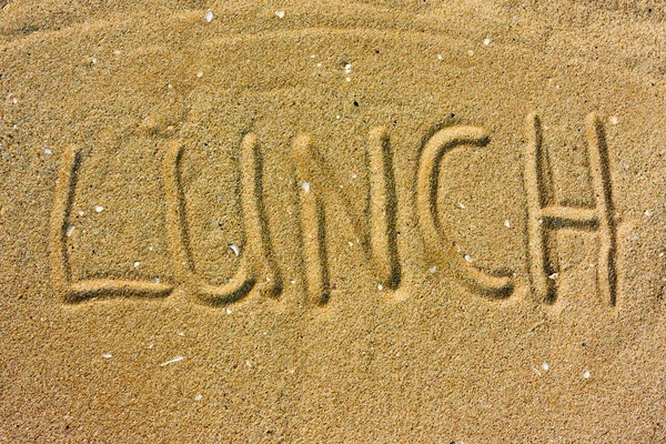 Надпись "Обед" на песке — стоковое фото