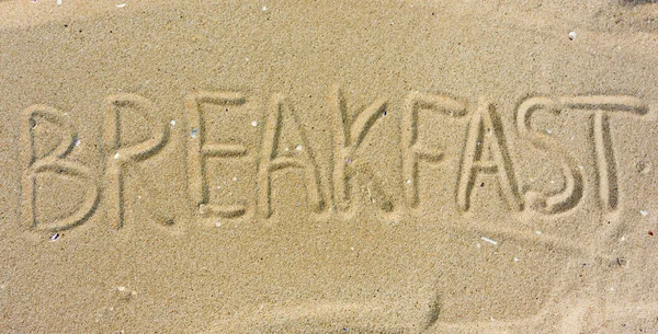 Надпись "Завтрак" на песке — стоковое фото
