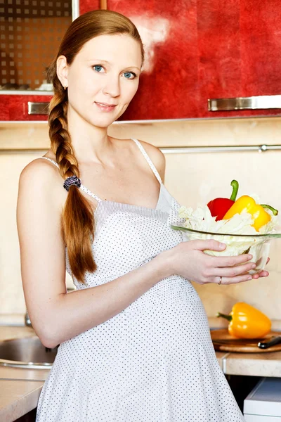 Mulher grávida na cozinha fazendo uma salada — Fotografia de Stock