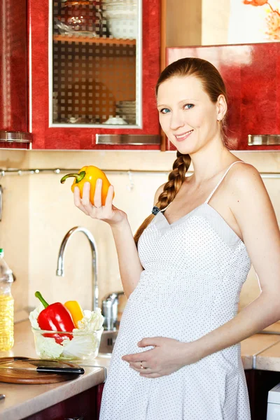 Έγκυος γυναίκα στην κουζίνα κάνοντας μια σαλάτα — Φωτογραφία Αρχείου