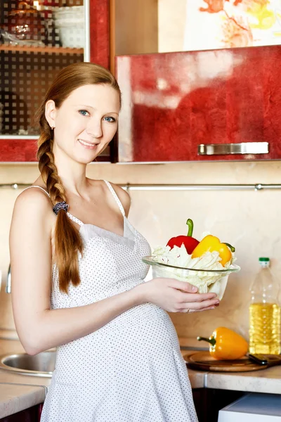Έγκυος γυναίκα στην κουζίνα κάνοντας μια σαλάτα — Φωτογραφία Αρχείου
