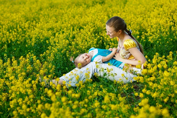 Moeder met baby op geel veld — Stockfoto