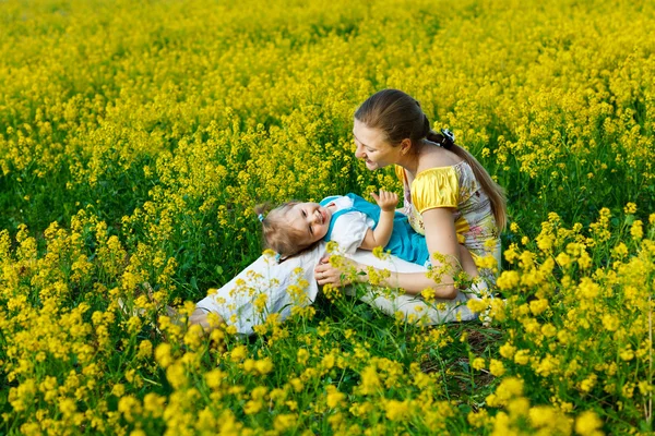 Mère avec bébé sur champ jaune — Photo