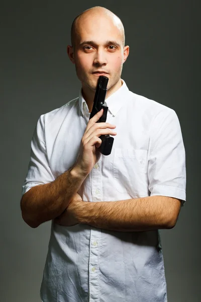 Handsome young man holding a gun — Stock Photo, Image