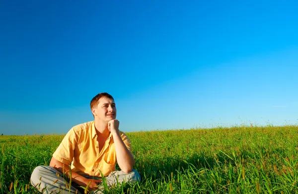 Человек сидит на поле — стоковое фото