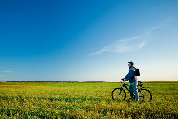 Man on bike in field — Stock Photo, Image
