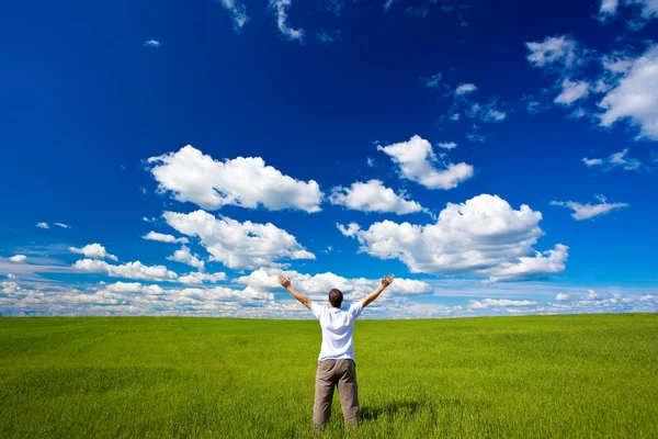 Человек на поле поднимает руки — стоковое фото