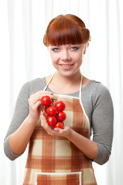 トマトとエプロンを着ている生姜の女性 — ストック写真