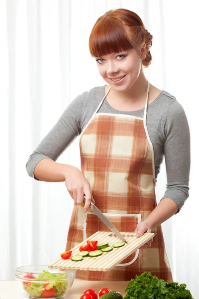 サラダ白を介して調理エプロンを着ている生姜の女性 — ストック写真