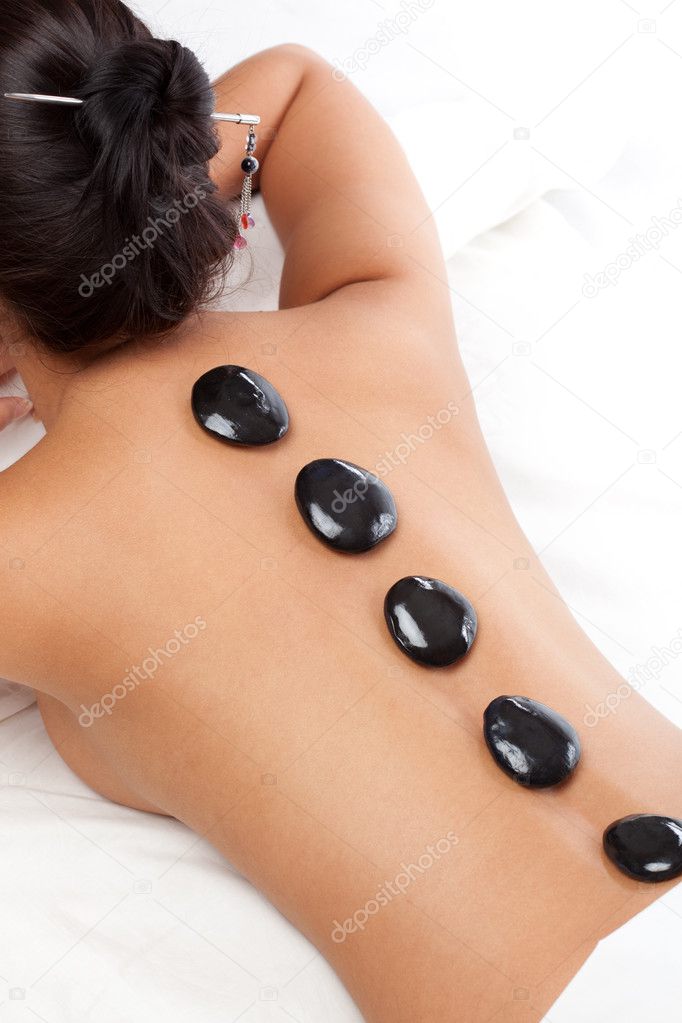 Pretty woman receiving a therapy with hot stones