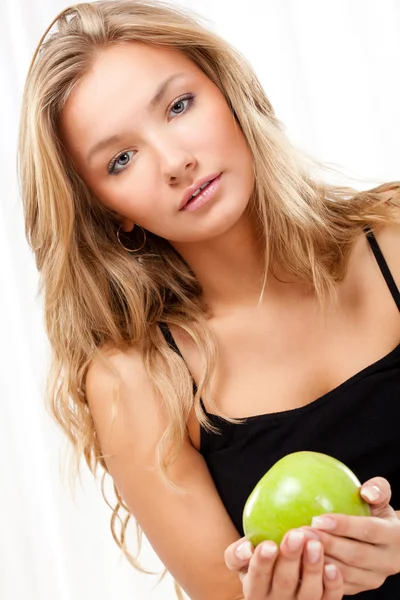 Yatakta oturmuş ve elma tutan güzel bir kadın — Stok fotoğraf