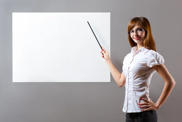Mulher mostrando com ponteiro para cartaz em branco — Fotografia de Stock