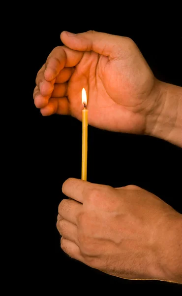 Uma mão segura uma vela — Fotografia de Stock