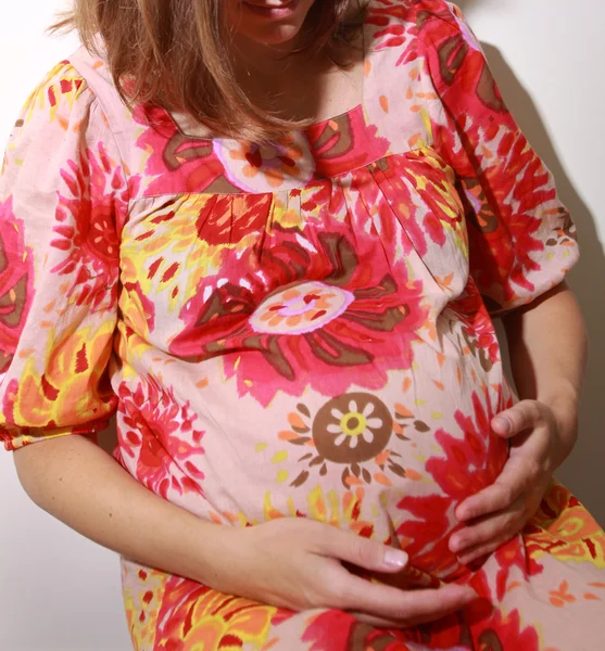 Sorridente donna incinta tenendo la pancia — Foto Stock