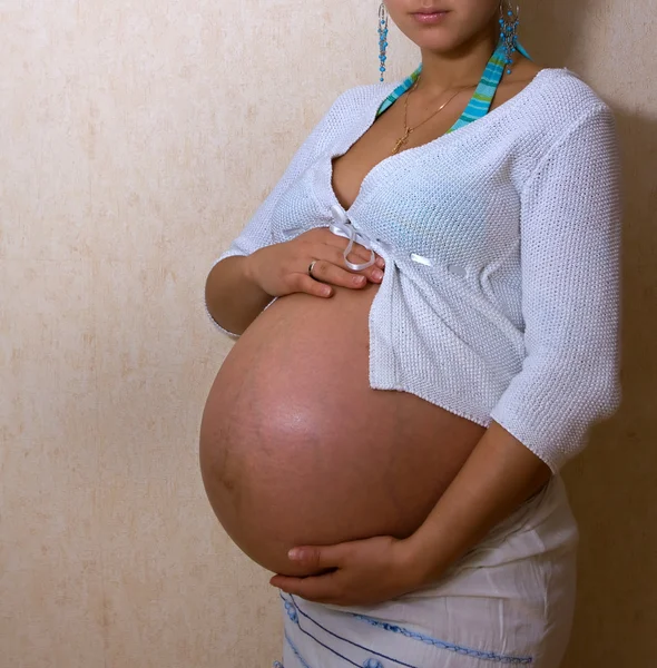 Fiatal terhes nő tartja a hasát — Stock Fotó
